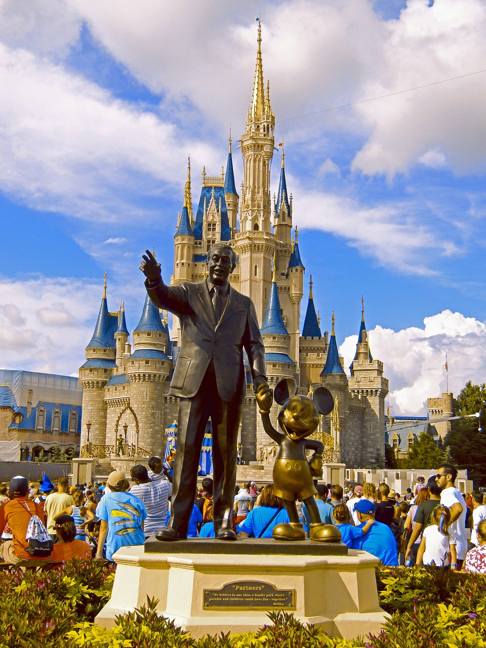 mickey mouse and walt disney statue at magic kingdom in front of the castle