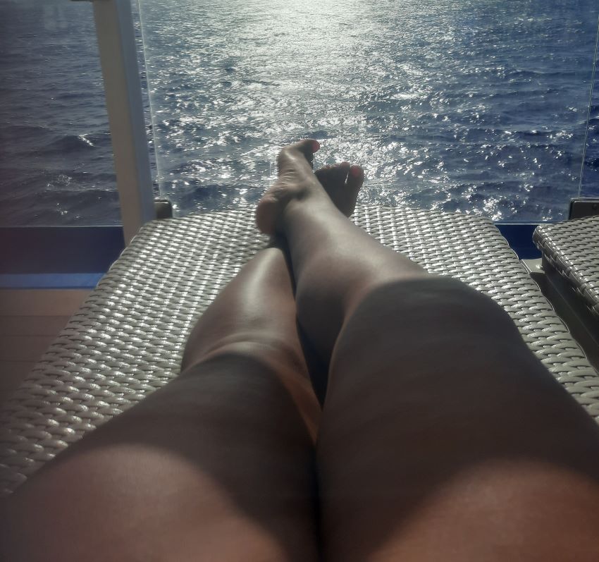 lounging on the Carnival Mardi Gras cruise ship pool side looking out at the ocean 